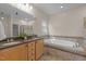 Bathroom with granite countertop, double sinks, and luxurious soaking tub with decorative tile surround at 311 Lilliput Ln, Wake Forest, NC 27587