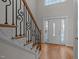 Foyer with decorative wrought iron railing, hardwood floors, and glass paned entry door at 311 Lilliput Ln, Wake Forest, NC 27587