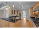 Bright kitchen features wood floors, stainless steel appliances, black counters, and custom cabinets at 311 Lilliput Ln, Wake Forest, NC 27587