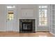 The living room has an elegant stone fireplace, a large window, and an exterior door at 311 Lilliput Ln, Wake Forest, NC 27587