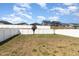 Spacious backyard with a well-maintained lawn, white privacy fence, and young tree at 332 Tumbling River Dr, Wendell, NC 27591