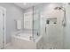 Bright bathroom featuring a soaking tub and separate shower with marble tile and glass door at 332 Tumbling River Dr, Wendell, NC 27591