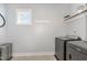 Laundry room featuring modern, black appliances, a floating shelf, and a view from the window at 332 Tumbling River Dr, Wendell, NC 27591