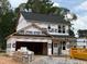 New construction home featuring a two-car garage awaiting finishing touches in a wooded community at 35 Fetterbush Way, Clayton, NC 27520