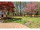 Large backyard with a patio, grass, trees, and a wooden fence at 4012 Old Sturbridge Dr, Apex, NC 27539