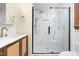 Bright bathroom featuring a wood vanity, a marble-look tiled shower, and brass fixtures at 4012 Old Sturbridge Dr, Apex, NC 27539