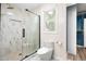 Beautiful bathroom featuring a glass shower with a rainfall shower head and white marble tiling at 4012 Old Sturbridge Dr, Apex, NC 27539