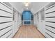 Walk-in closet with white organizers and cabinets, wood floors, and a blue accent wall at 4012 Old Sturbridge Dr, Apex, NC 27539
