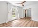 Bright living room with wood floors, large window with white curtains, and view to the rest of the home at 4012 Old Sturbridge Dr, Apex, NC 27539