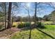 Lush backyard with mature trees and landscaping, leading to a tranquil waterfront at 406 Southshore Pkwy, Durham, NC 27703