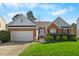 Charming brick home with an attached two-car garage, manicured lawn, and inviting front porch at 406 Southshore Pkwy, Durham, NC 27703