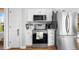 Well-lit kitchen featuring stainless steel appliances, white cabinets, and a decorative backsplash at 406 Southshore Pkwy, Durham, NC 27703