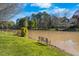 Scenic view of the waterfront featuring lush greenery, benches, and a serene pond at 406 Southshore Pkwy, Durham, NC 27703