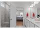 Bright bathroom featuring double vanity, walk-in shower, and an open view to the bedroom at 428 Beaverdam Lake Dr, Fuquay Varina, NC 27526