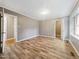 A large bedroom with wood-look floors, neutral walls, with two entryways and a window at 4508 Old Us 421 N, Siler City, NC 27344