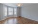 A bedroom with natural light from the bay windows, a ceiling fan, and wood flooring at 469 Winding Wood Dr, Clayton, NC 27520
