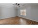 A spacious bedroom with a tray ceiling, natural light, a ceiling fan, and wood floors at 469 Winding Wood Dr, Clayton, NC 27520