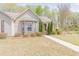 A home with a well-kept lawn and a concrete path, bordered by trees, leading to the front entrance at 469 Winding Wood Dr, Clayton, NC 27520