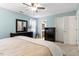 Bedroom with soft blue walls and neutral carpet, bed with nightstands and dresser with mirror at 4725 Sinclair Dr, Raleigh, NC 27616