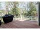 View of the wooden deck, featuring white railings and an outdoor grill surrounded by lush greenery at 4725 Sinclair Dr, Raleigh, NC 27616