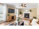 Cozy living room with fireplace, hardwood floors, ceiling fan, and natural light at 4725 Sinclair Dr, Raleigh, NC 27616