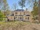 Backyard view of home featuring light yellow siding, a fireplace, and a lush green lawn at 4818 Glendarion Dr, Durham, NC 27713