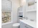 Cozy bathroom features a vanity with sink and storage, toilet and window with backyard view at 4818 Glendarion Dr, Durham, NC 27713