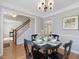 Cozy dining area features a table set for four, hardwood floors, and a view of the staircase at 4818 Glendarion Dr, Durham, NC 27713