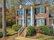 Traditional brick home with classic architectural details, featuring a columned entrance, black shutters, and manicured shrubs at 4818 Glendarion Dr, Durham, NC 27713
