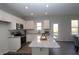 Well-lit kitchen with granite countertops, stainless steel appliances, a central island, and a backyard view at 49 Fetterbush Way, Clayton, NC 27520