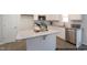 Modern kitchen with white cabinetry, granite countertops, stainless steel appliances, and a kitchen island at 49 Fetterbush Way, Clayton, NC 27520