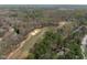 Aerial view of a well-maintained golf course with sand traps and trees, surrounded by homes at 5220 Linksland Dr, Holly Springs, NC 27540