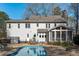 Back exterior view features a refreshing swimming pool, screened-in porch, outdoor furniture, and well-maintained landscaping at 5220 Linksland Dr, Holly Springs, NC 27540