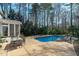Back exterior showcases a sparkling pool with ample lounging space and a charming screened-in porch for relaxation at 5220 Linksland Dr, Holly Springs, NC 27540
