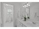 All-white bathroom featuring double vanity, mirrors, and tiled floors at 5220 Linksland Dr, Holly Springs, NC 27540
