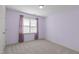 Empty bedroom with lilac walls, carpet, and a large window at 5220 Linksland Dr, Holly Springs, NC 27540