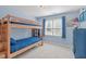 Blue-themed bedroom with bunk beds, carpet, and natural light at 5220 Linksland Dr, Holly Springs, NC 27540