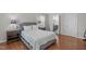 Bedroom featuring a luxurious grey bed frame, hardwood floors, and connected bathroom at 5220 Linksland Dr, Holly Springs, NC 27540