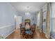 Charming dining room with hardwood floors, crystal chandelier, and large windows providing plenty of natural light at 5220 Linksland Dr, Holly Springs, NC 27540