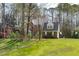 Attractive brick home on large lawn surrounded by mature trees and foliage at 5220 Linksland Dr, Holly Springs, NC 27540