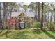 Beautiful brick home with blue door and lush landscaping and mature trees at 5220 Linksland Dr, Holly Springs, NC 27540