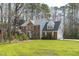 Beautiful two-story brick home with a well-maintained lawn and tree line at 5220 Linksland Dr, Holly Springs, NC 27540