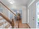 Inviting foyer with hardwood floors, staircase, and a glimpse into the dining room featuring a crystal chandelier at 5220 Linksland Dr, Holly Springs, NC 27540