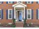 Welcoming front entrance with brick steps and a charming blue front door at 5220 Linksland Dr, Holly Springs, NC 27540