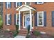 Inviting front entrance featuring a blue door, brick steps, and classic details at 5220 Linksland Dr, Holly Springs, NC 27540