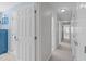 Carpeted hallway with neutral walls and white doors leading to various rooms at 5220 Linksland Dr, Holly Springs, NC 27540
