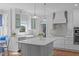 Modern kitchen with a large central island and stainless appliances offers a functional workspace at 5220 Linksland Dr, Holly Springs, NC 27540