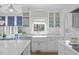 Bright kitchen features white cabinets, hardwood floors, a farmhouse sink and stainless appliances at 5220 Linksland Dr, Holly Springs, NC 27540
