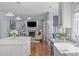Open-concept kitchen and living room with modern lighting, island, and fireplace at 5220 Linksland Dr, Holly Springs, NC 27540