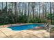 Inviting in-ground pool with lounge chairs and a cozy stone fire pit at 5220 Linksland Dr, Holly Springs, NC 27540